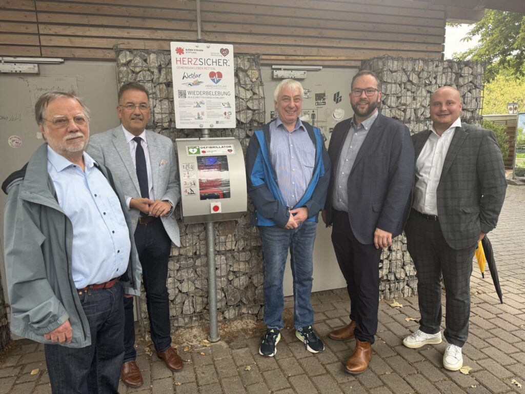 Die genannten Personen vor dem Defibrillator